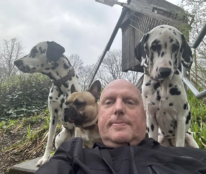 Marc mit seinen zwei Dalmatinern und seiner Französischen Bulldogge bei einem Spaziergang.